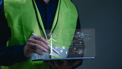 A business owner reviewing energy data on a tablet. Engineer holding tablet manages renewable energy systems featuring wind turbine holographic data visualization inside modern industrial technology