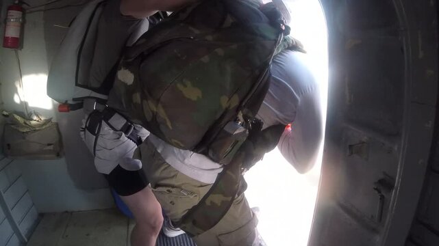 Man jumps out of a plane with a parachute.
