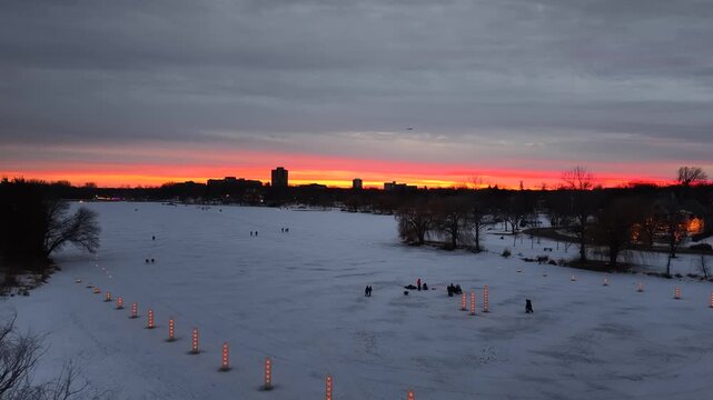 SAINT PAUL - 2.24.2026 - Stunning aerial view of people walking on a frozen lake in St. Paul, Minnesota at sunset.