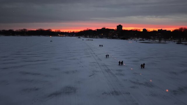 SAINT PAUL - 2.24.2026 - Gorgeous aerial footage following people as they walk up a frozen lake in St. Paul, Minnesota at night.