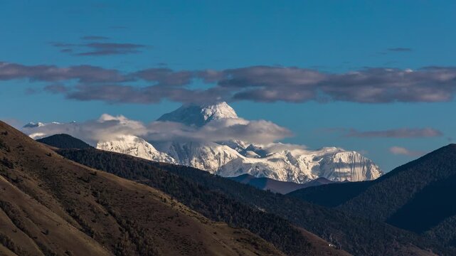 Snow-Capped Mountain Peaks Above Forested Valleys