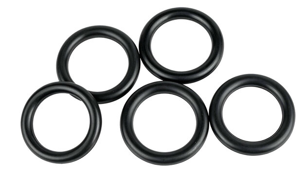 Five black circular rubber rings, randomly arranged against a black background