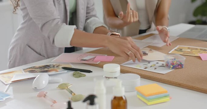 African American women during brief writing notes placing photos on corkboard at studio for review
