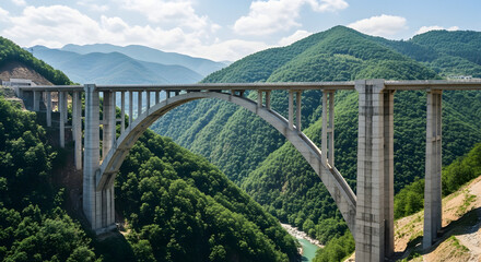 Fototapeta premium A majestic stone arch bridge spans a turquoise mountain river, blending historic architecture with the rugged landscape of a nature tourism landmark under a clear blue sky