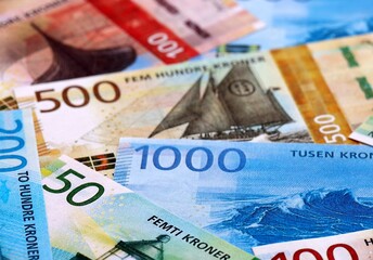 Norwegian krone money bills pile on table. Norway banknotes of NOK currency close up.