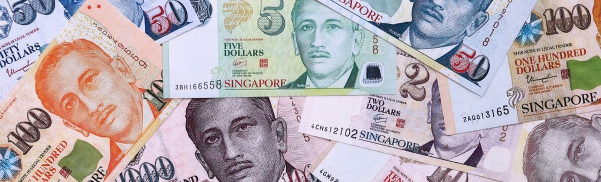Singapore dollar money bills pile on table. Singapore banknotes of SGD currency close up.
