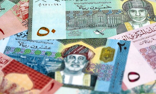 Omani rial money bills pile on table. Oman banknotes of OMR currency close up.