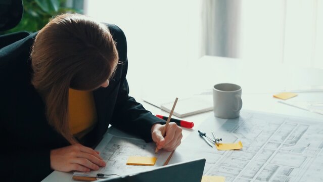 Top view of smart civil engineer drawing and measuring blueprint by using ruler. Aerial view of architect scatch building project plan at meeting table with equipment and safety helmet. Alimentation.
