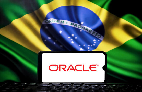 Oracle logo on a cell phone screen with the Brazilian flag in the background. Technology and investment concept.