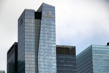 Naklejka premium Toronto, Canada - February 15, 2026: Modern glass office towers in downtown Toronto featuring the Delta building and Marsh McLennan headquarters under a cloudy urban skyline
