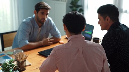Executive manager explain financial graph to colleague at meeting room. Top aerial view of diverse marketing team sharing idea and planning strategy while sitting at table with tablet. Convocation.