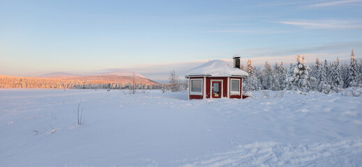 Winter wonderland in Akaslompolo, Lapland, showcasing a cozy cabin in a snowy landscape