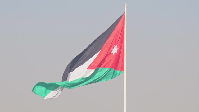 Aerial view The Raghadan Flagpole dominates the Amman skyline, Jordan. This monumental national flag towers over traditional limestone architecture and the dense urban hillside of the capital.