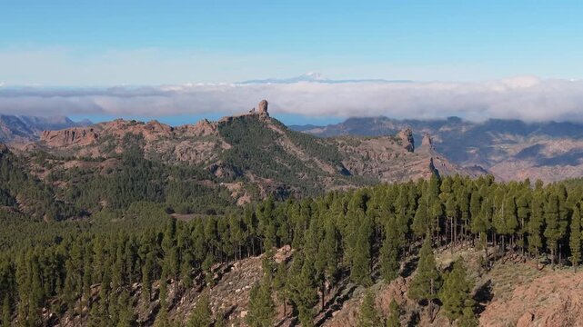 Beautiful panoramic shot of Roque Nublo with the Teide volcano visible above the clouds. Breathtaking mountain landscape in Gran Canaria