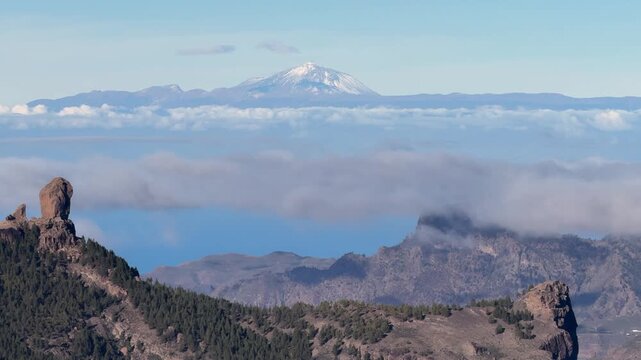 Stunning panoramic view from Gran Canaria showing Roque Nublo and the snowy Teide volcano on Tenerife island emerging from a sea of clouds
