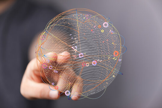 Abstract image of a globe-like structure held in a person's hand, representing the interconnectedness of the world, com