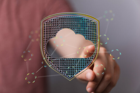 Secure digital cloud data concept. Hand pointing at a digital cloud and shield, symbolizing data protection and securit