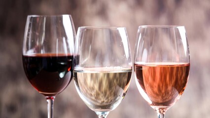 Naklejka premium Three wine glasses filled and arranged on indoor table.