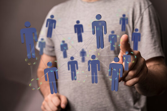 Close-up of a man's finger interacting with a holographic representation of a social network, business network, and huma