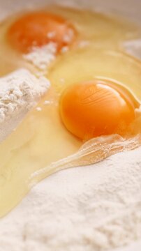 Raw egg yolk and white flour in a bowl for baking preparation