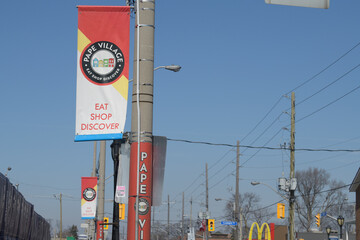 Naklejka premium projecting banners mounted on poles at Pape Village, looking north on Pape Av, Toronto