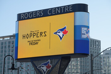 Naklejka premium Rogers Centre Gardiner LED pylon sign featuring ad for Disney/Pixar film and Toronto Blue Jays logo, Toronto