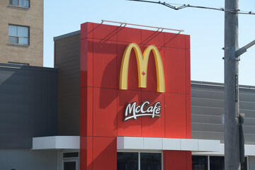 Naklejka premium exterior building facade and sign of McDonald's + McCafé fast food chain located here at 1045 Pape Av, Toronto