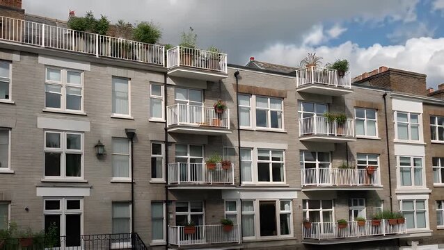 A contemporary housing structure displaying iterative facade designs and external platforms within a metropolitan setting, indicative of property development.