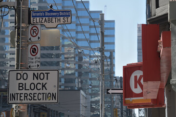 Naklejka premium looking west on Dundas St W to street and shop signs incl Circle K, a convenience store chain, located here at 144 Dundas St W, Toronto