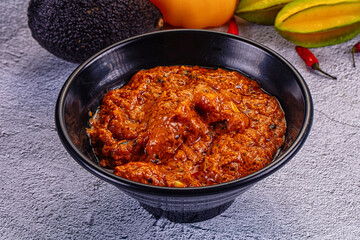 Indian butter chicken masala, a spicy traditional curry served in a bowl on a textured background.