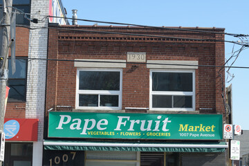 Naklejka premium exterior building facade and sign of Pape Fruit Market at 1007 Pape Av, East York, Toronto