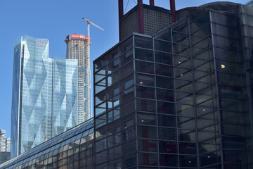 Naklejka premium (in the shadows) exterior of SkyWalk a bridge and a defocused view of CIBC Square and SkyTower at Pinnacle One Yonge, Toronto