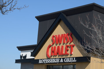 Naklejka premium exterior building facade and sign of Swiss Chalet, a restaurant chain, located here at 1400 O'Connor Dr, East York, Toronto