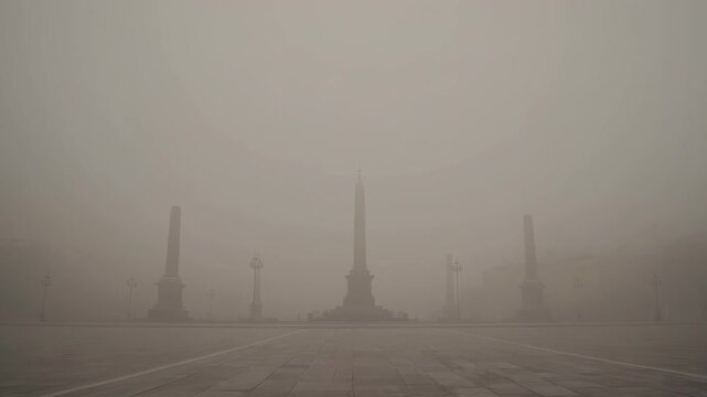 A large, classical palace or government building is barely visible through a dense layer of gray mist and smog. This atmospheric scene conveys a sense of mystery, isolation, or high pollution.
