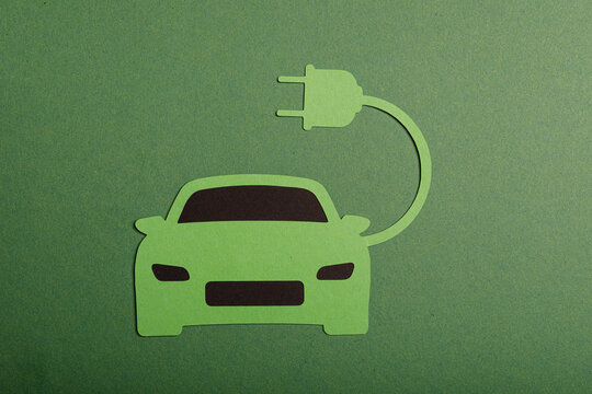 Eco-friendly electric car charging concept on a green background. Future transportation and sustainable energy. Zero emi