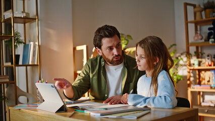 Obraz premium Father explaining school task teenage daughter at apartment desk closeup. 