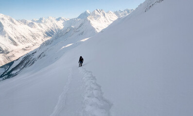 A lone mountaineer's winter fairytale hike against a backdrop of stunning, unique mountain scenery.