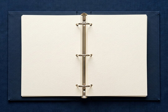 Open dark blue ring binder with blank pages on matching background