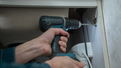 The technician removes the door from the kitchen cabinet.