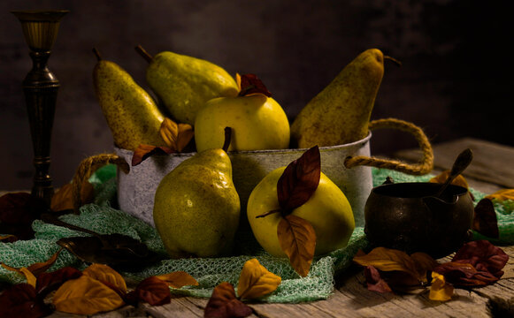 Natura morta con frutti e foglie autunnali.