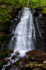 Obraz premium temporary watershed creates a cascade waterfall in the mountains as melted snow flows down 