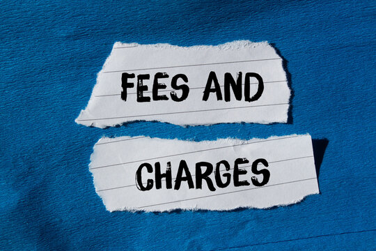Fees and charges message written on ripped torn paper background. Conceptual Fees and charges symbol. Copy space.