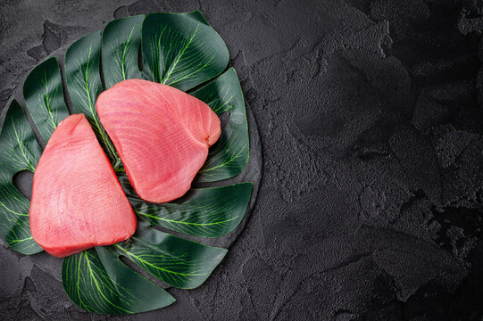 Beautifully cut raw tuna steak, rich in flavor and omega 3s, ready to elevate your culinary creations. black background. top view