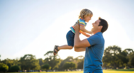 Fototapeta premium A happy father playing with his little child in a park on a sunny day