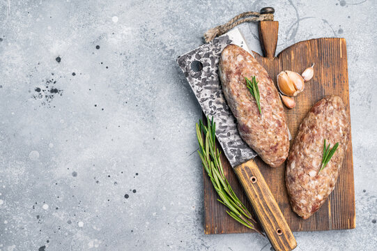 Succulent raw kofta kebab pieces marinated in spices, ideal for grilling enthusiasts looking to elevate their barbecue game. grey background. top view