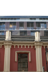 Historic red facade beneath modern glass, decorative cornice and column details meet sleek aluminum panels, layered materials and strong geometry, © Alena