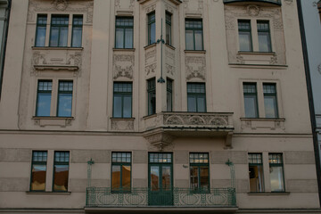 Obraz premium Symmetrical facade with central balcony detail. Formal city residence portrait featuring pilasters, carved railing, balanced fenestration, subtle