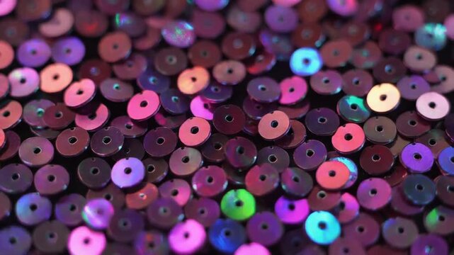 Colorful sequins scattered on a surface creating a shiny texture