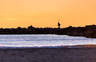 Fisherman Silhouette at Dawn on Calm Ocean Horizon