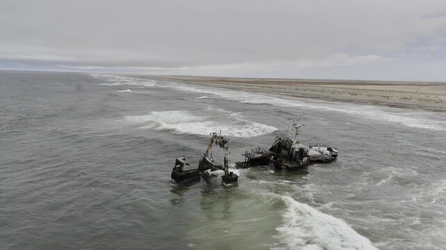 Drone does a 360 around the Zeila Shipwreck on the Skeleton Coast on partially cloudy day in the desert in Namibia